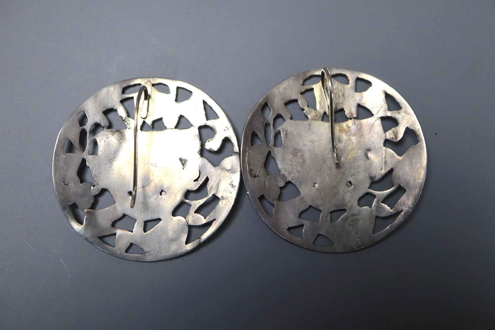 A pair of continental pierced white metal foliate and mask concave circular earrings, 38mm, gross 14.5 grams.